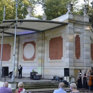 Zdjęcie przedstawia publiczność oraz scenę amfiteatru świerklanieckiego parku podczas koncertu pt. Jesienne odgłosy wiosny