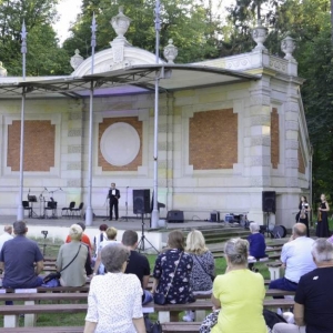 Zdjęcie przedstawia publiczność oraz scenę amfiteatru świerklanieckiego parku podczas koncertu pt. Jesienne odgłosy wiosny